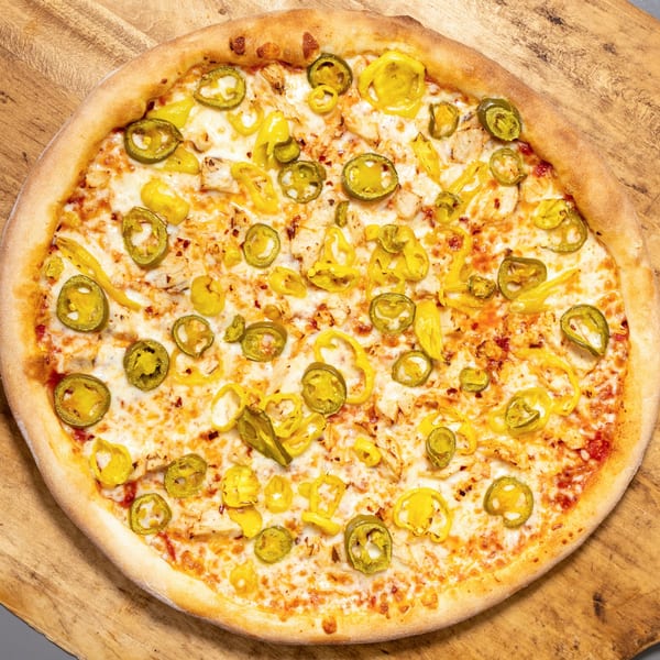 Uncle Vito's Pizzeria's chicken pizza with melted cheese, green jalapeños, and yellow banana peppers.