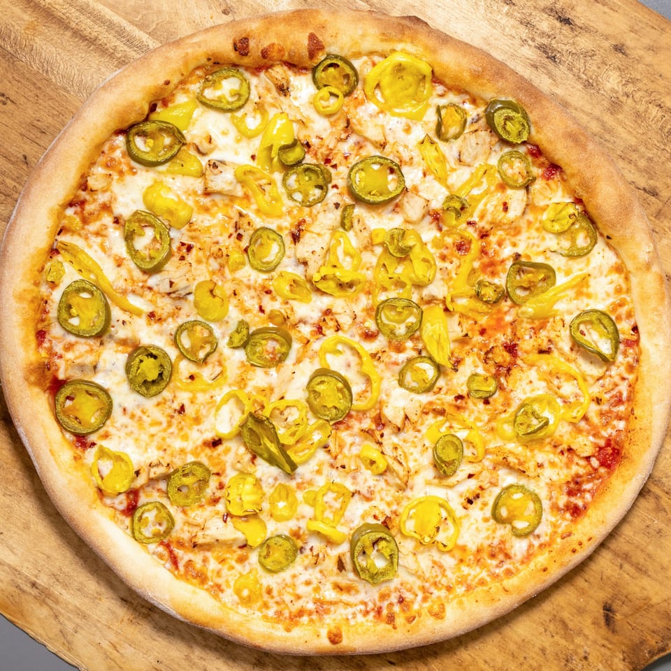 Uncle Vito's Pizzeria's chicken pizza with melted cheese, green jalapeños, and yellow banana peppers.